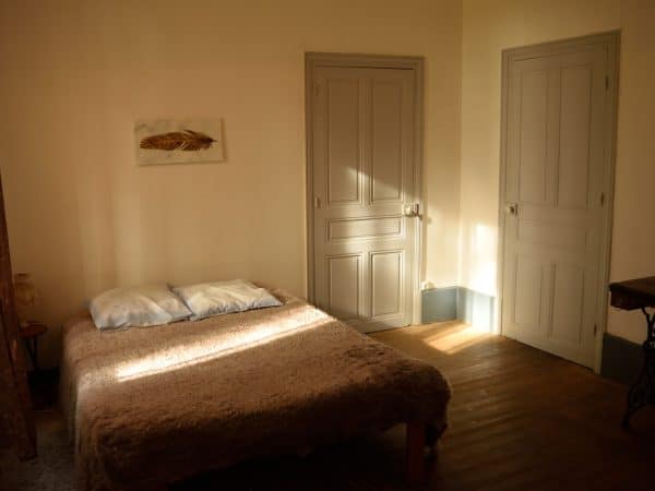 a bed sitting in a bedroom next to two doors